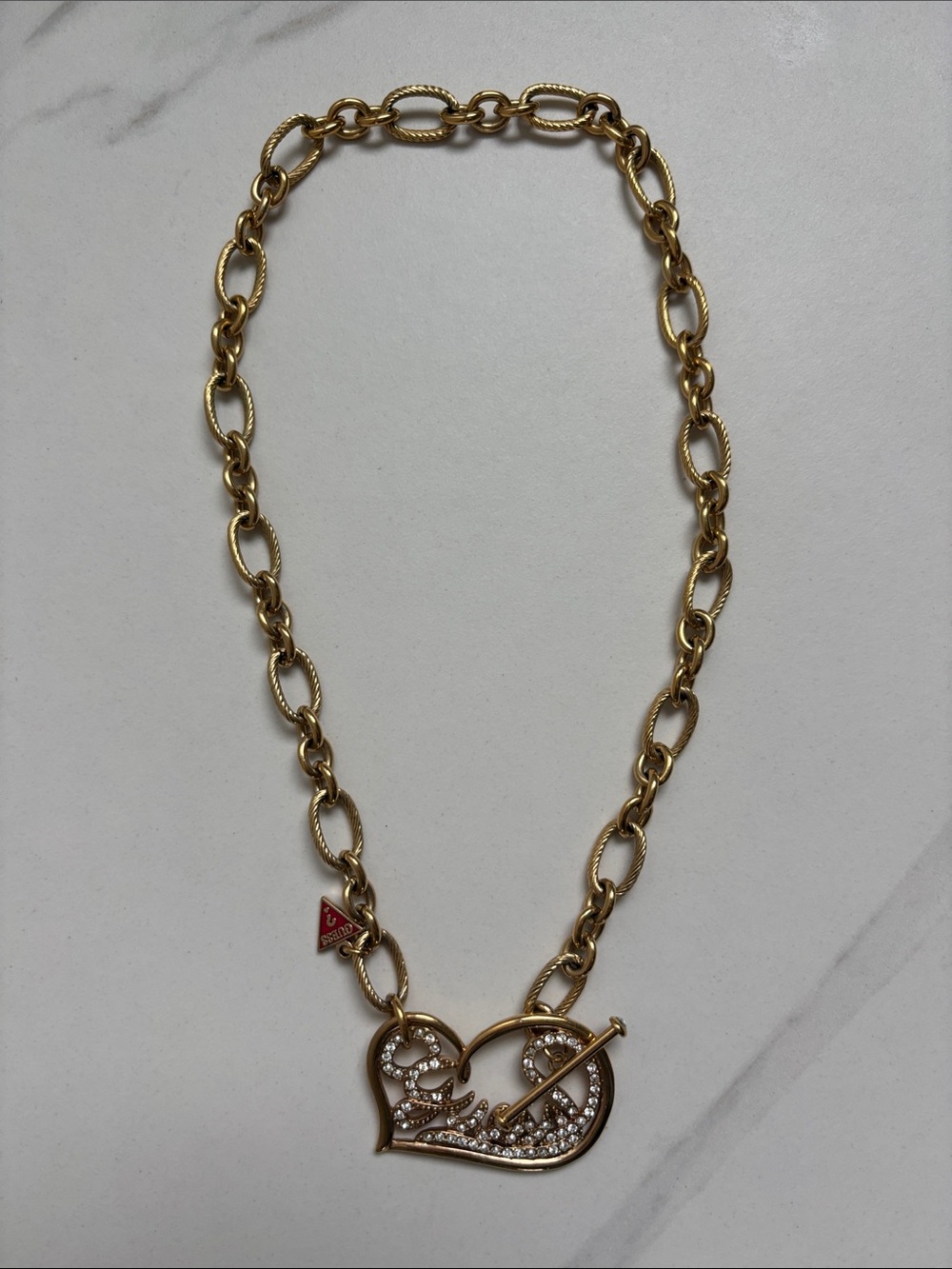 Guess Gold-Tone Heart Pendant Necklace with Crystal Accents and Red Logo Tag